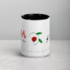 Two-tone ceramic mug with red and black floral design.