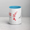 White coffee mug with blue interior, red hearts, and black graphic.