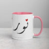 White and pink Noor Arabic calligraphy coffee mug with heart accent.