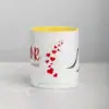 White ceramic coffee mug with yellow interior and red heart graphic.