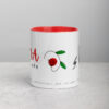 White ceramic coffee mug with red interior and floral design.