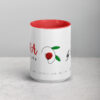 Red interior white ceramic coffee mug with uplifting black, red, green design.