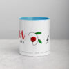 White ceramic coffee mug with blue interior, modern text, and floral design.